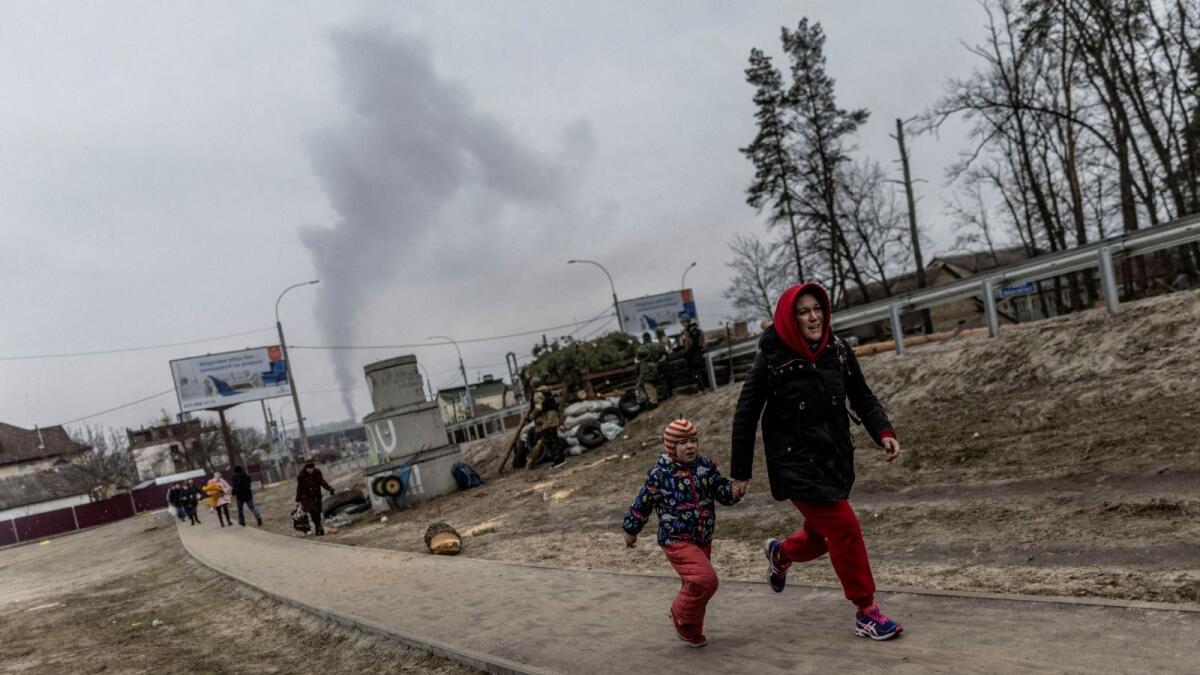 Local residents run for cover as they escape from the town of Irpin, after heavy shelling on the only escape route used by locals, while Russian troops advance towards the capital of Kyiv, in Irpin, near Kyiv, Ukraine, March 6, 2022. (Photo: Reuters)