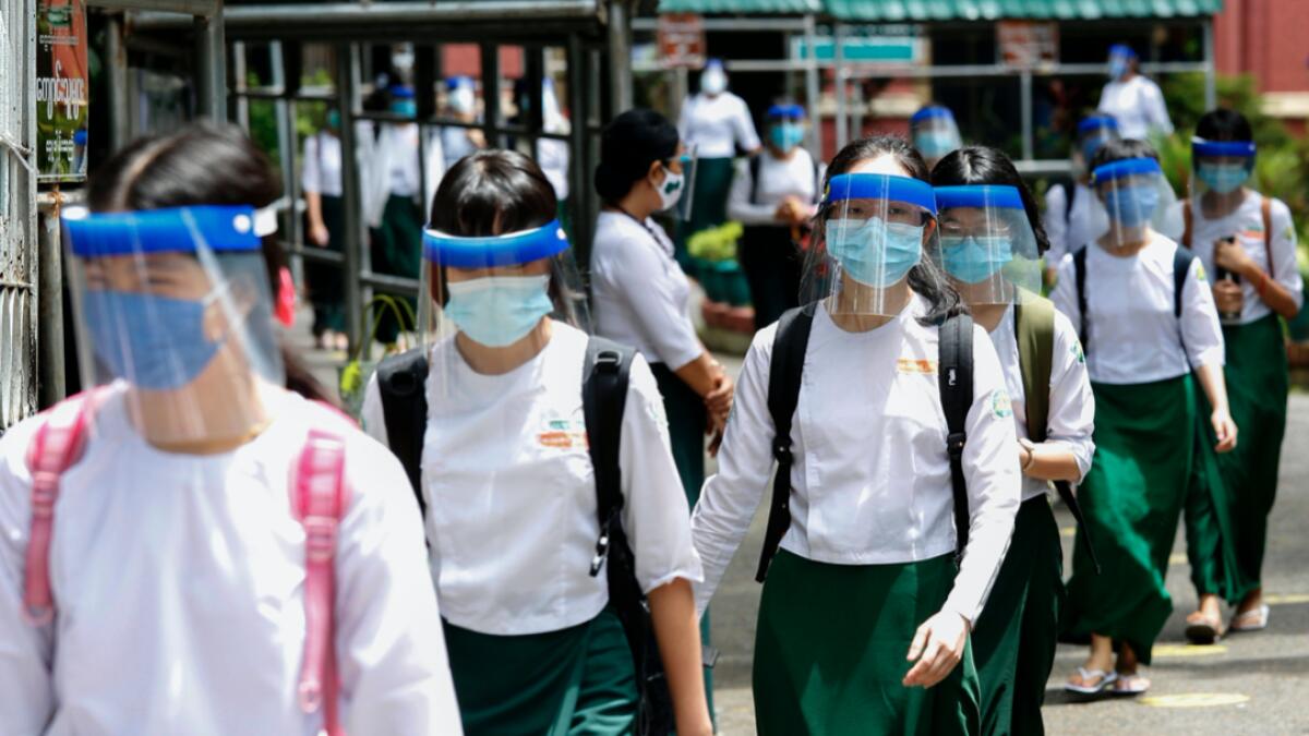 Students wearing masks and face shields leave after attending classes during the first day of reopening of public high schools following closure due to the Covid-19 coronavirus in Yangon, Myanmar. Photo: AFP