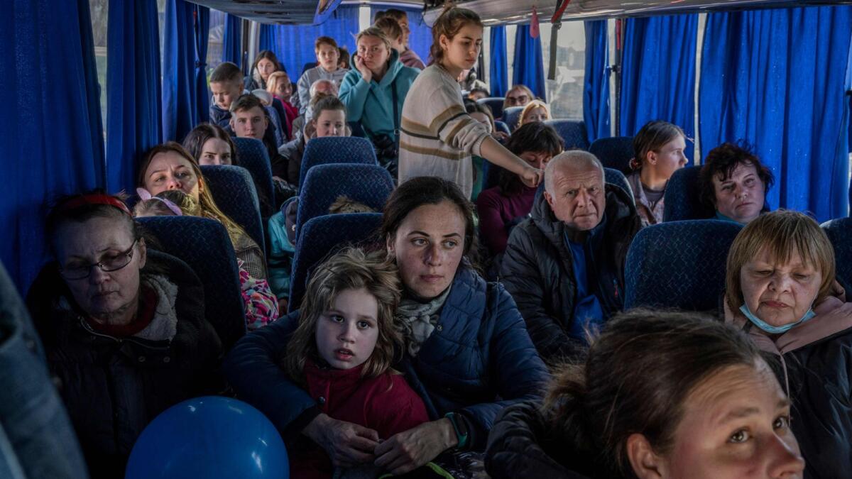 Ukrainian evacuees stand on a bus carrying refugees, after crossing the Ukrainian border with Poland at the Medyka border crossing. (AFP)