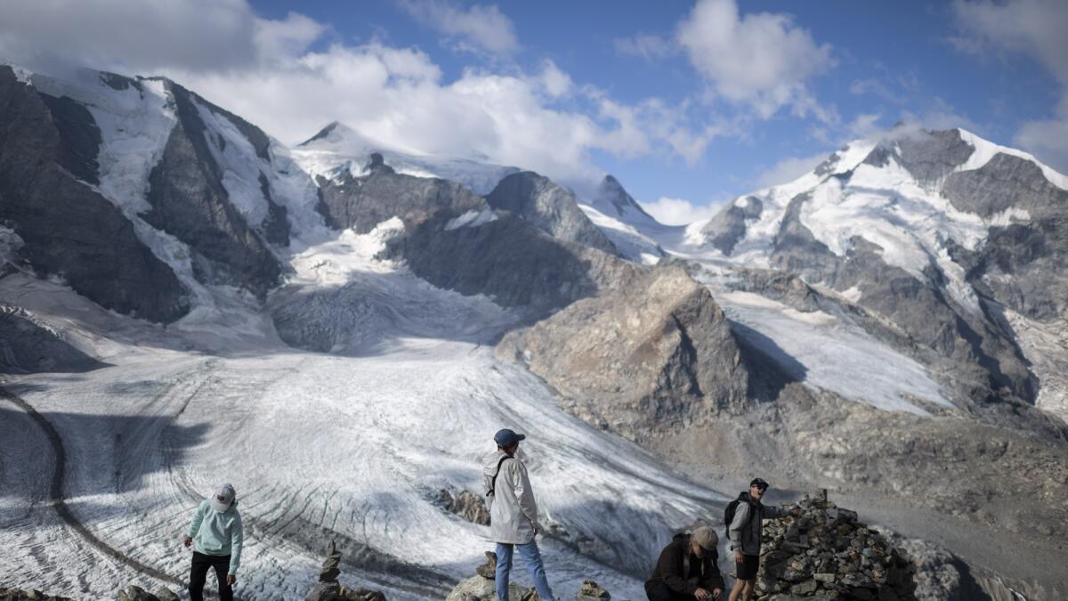 People stay in front of the Bernina mountain group with the Pers and Morteratsch glaciers in Pontresina, Switzerland,  on August 10. — AP