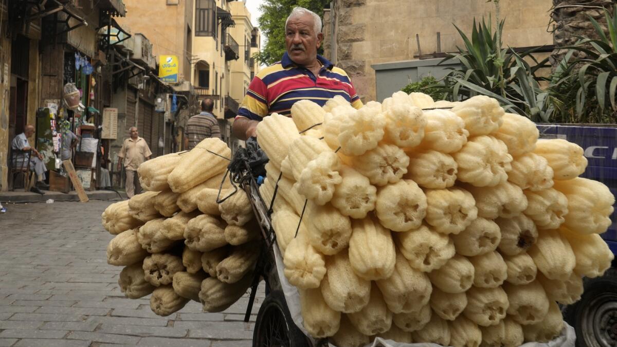 A luffa vendor looks for customers in Cairo, Egypt. For decades, millions of Egyptians have depended on the government to keep basic goods affordable. - AP file
