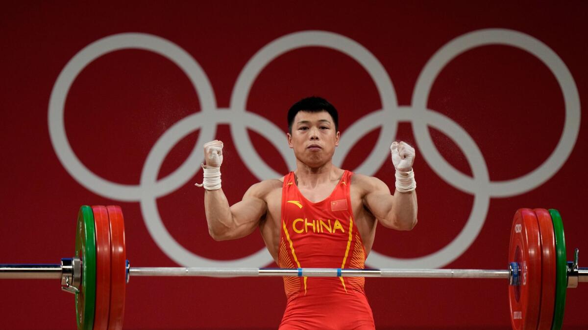Chen Lijun of China celebrates after a lift as he competes in the men's 67kg weightlifting event. — AP