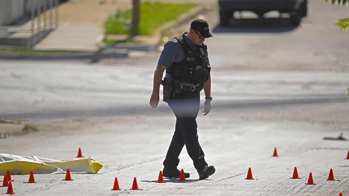 Evidence markers filled the street as police were investigating the scene after three people died following a shooting near 57th Street and Prospect Avenue in Kansas City. — AP