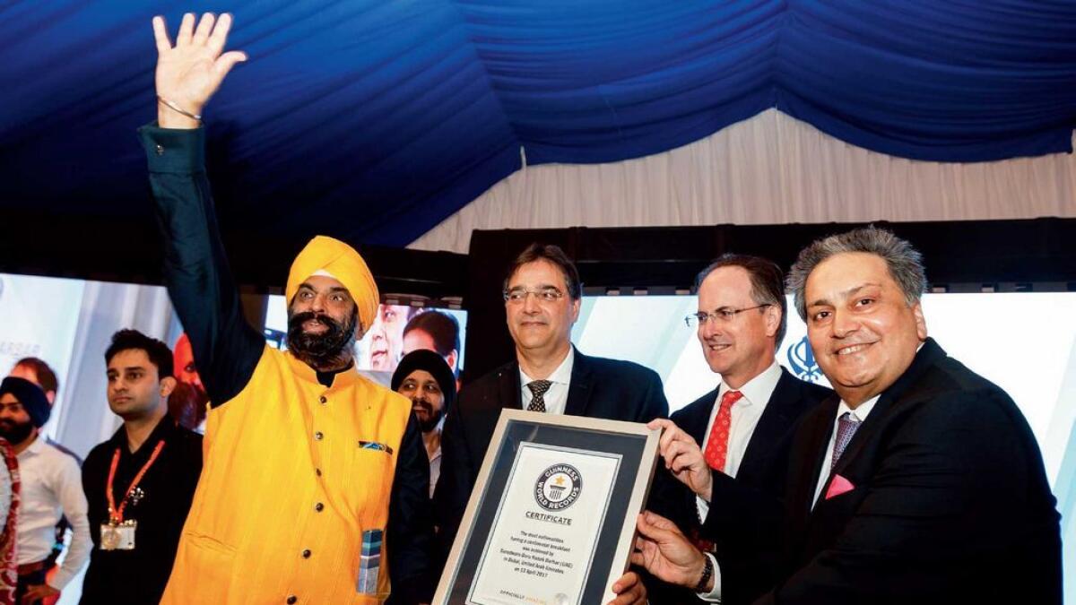 (From left) Surender Kandhari, Gurudwara chairman; Masud Husain, Canadian Ambassador to UAE; Philip Parman, the UK Ambassador and Kamal Vachani, Group Director of Al Maya, with the certificate.- Photo by Neeraj Murali
