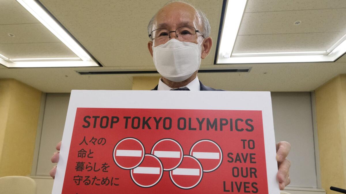 Kenji Utsunomiya, a Japanese lawyer, displaying a campaign poster calling for the cancellation of the Tokyo Olympics. (AFP)