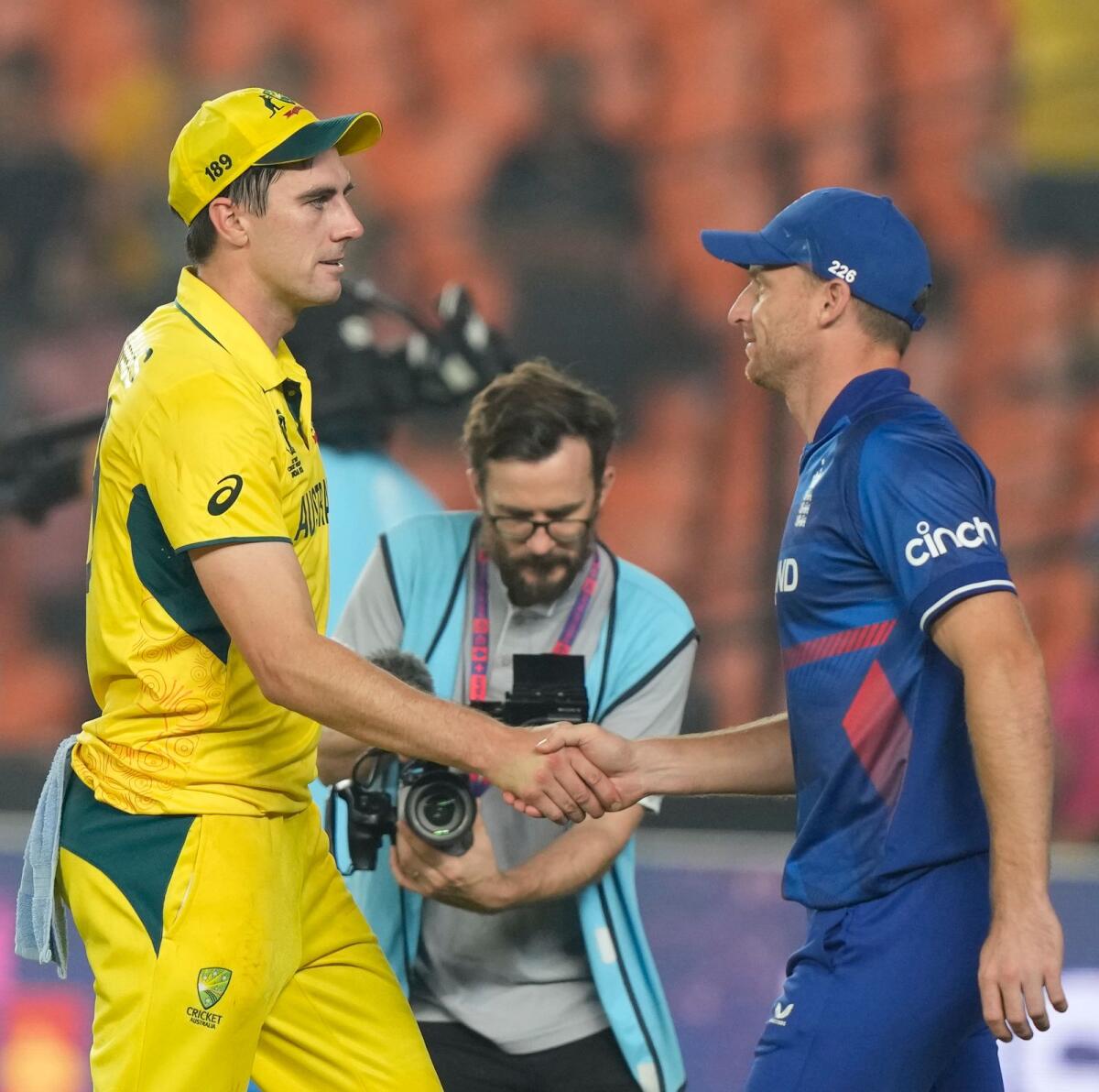 England captain Jos Buttler (right) congratulates Australian skipper Pat Cummins after the match. — AP