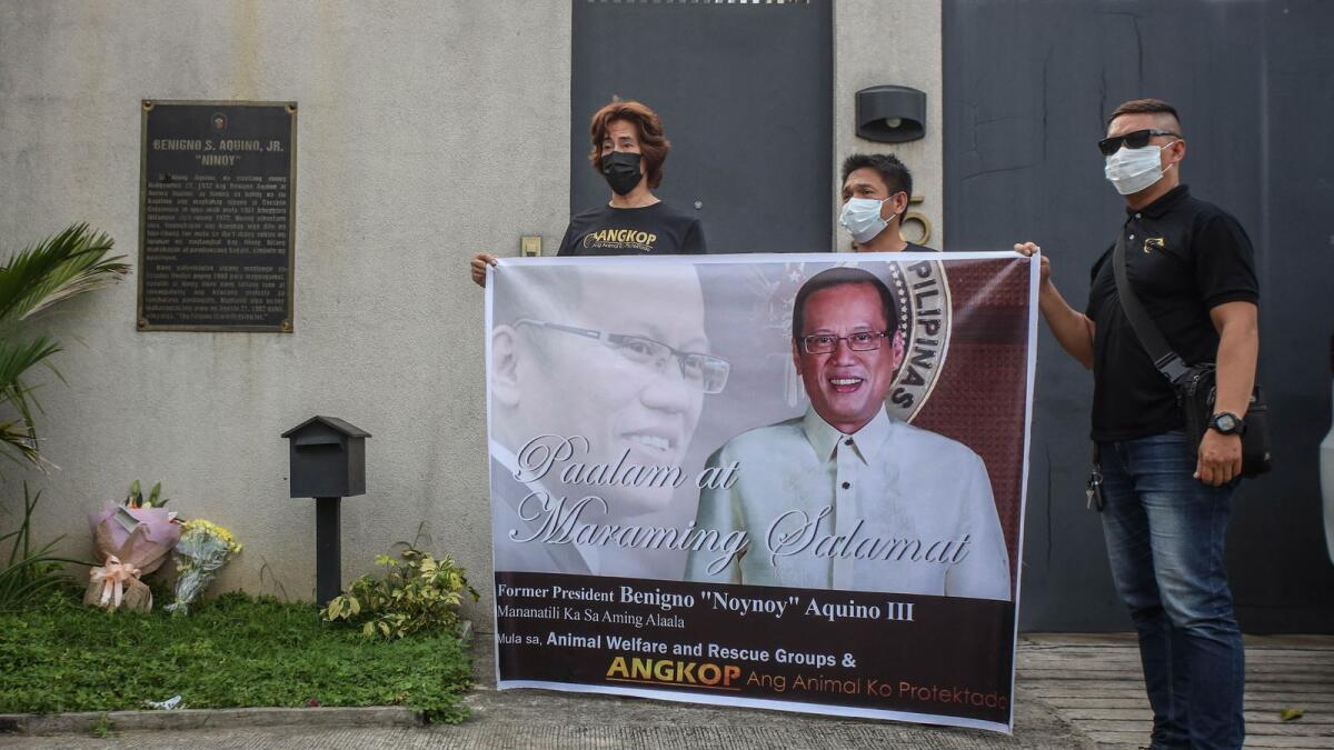 People display a portrait of Philippine president Benigno Aquino near his residence in Manila. Photo: AFP