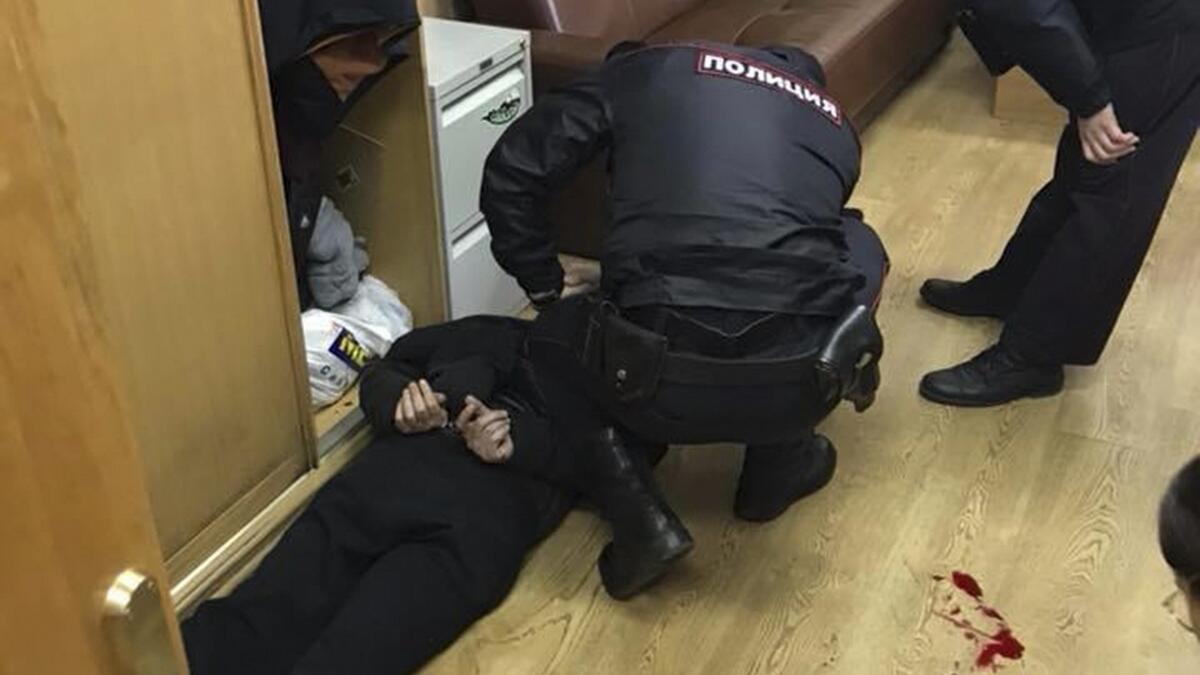Policemen detain an intruder, who attacked Tatyana Felgengauer, anchor of Russian radio station Ekho Moskvy, in Moscow, Russia October 23, 2017.