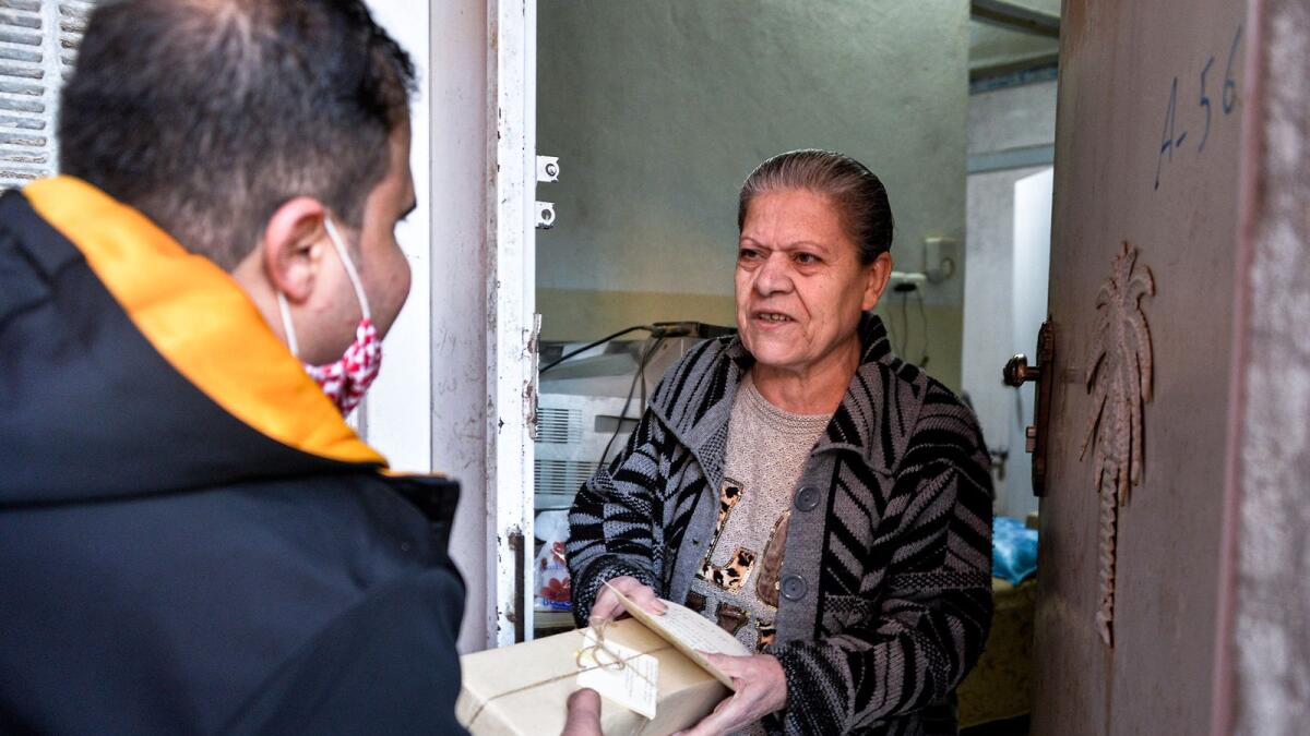 A volunteer delivers to a resident of Iraq's northern Christian town of Qaraqosh a Christmas gift package on Christmas Eve on December 24.