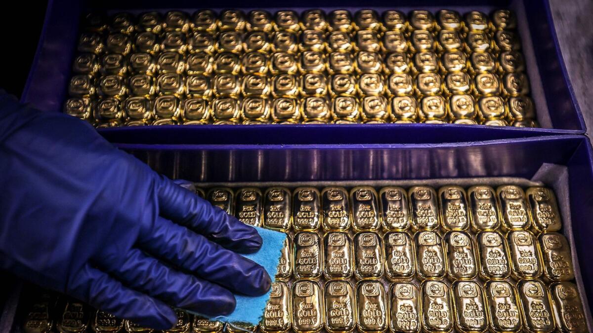 A worker polishes gold bullion bars at  a refinery in Sydney. — AFP