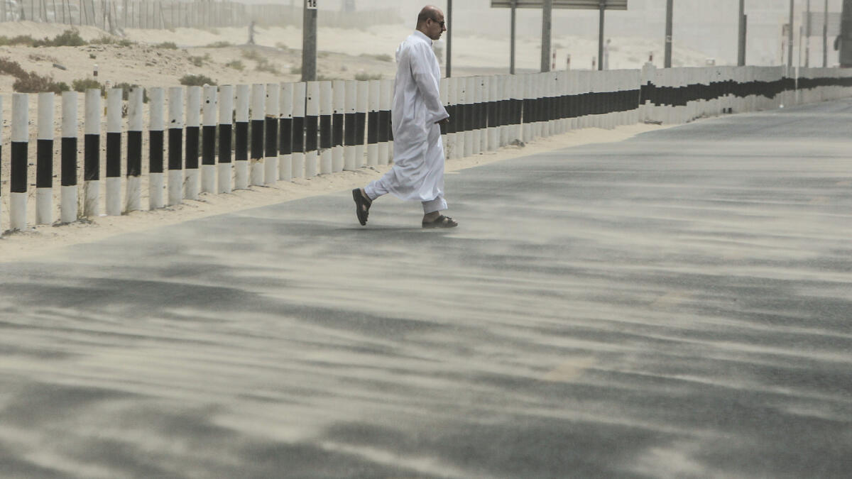 A pedestrian walks on a windy and hazy day in Dubai.- Photo by Shihab/ Khaleej Times