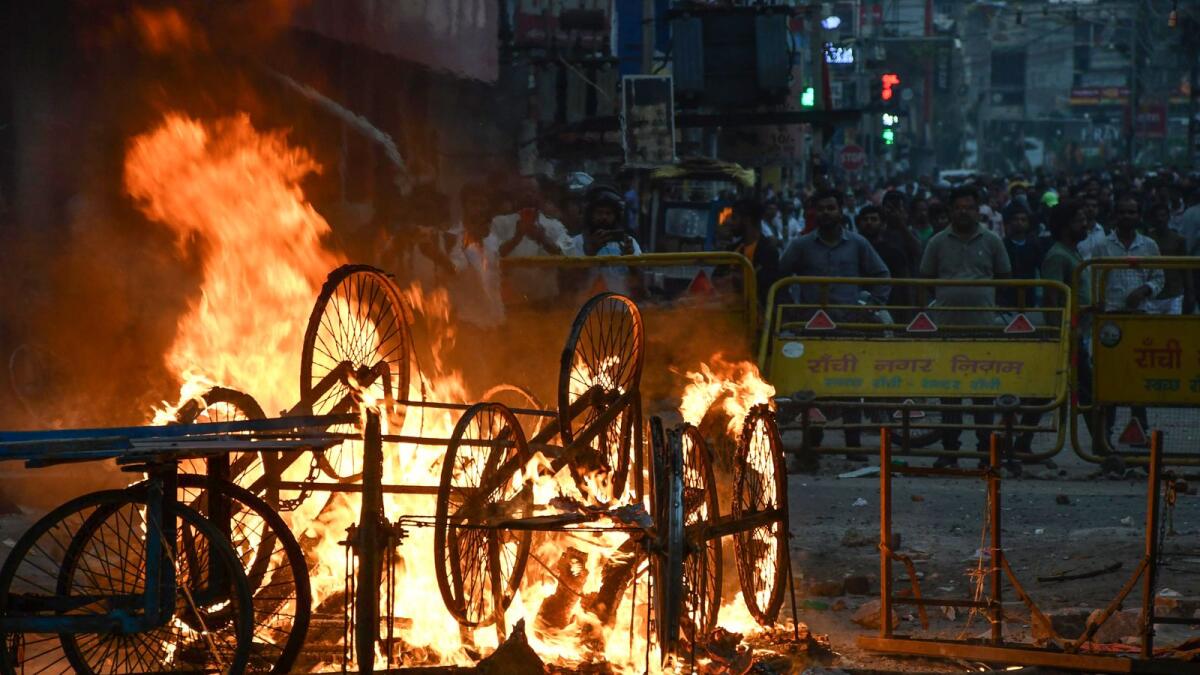 Overturned handcarts are seen in flames following a protest in Ranchi on June 10, 2022. Photo: AFP