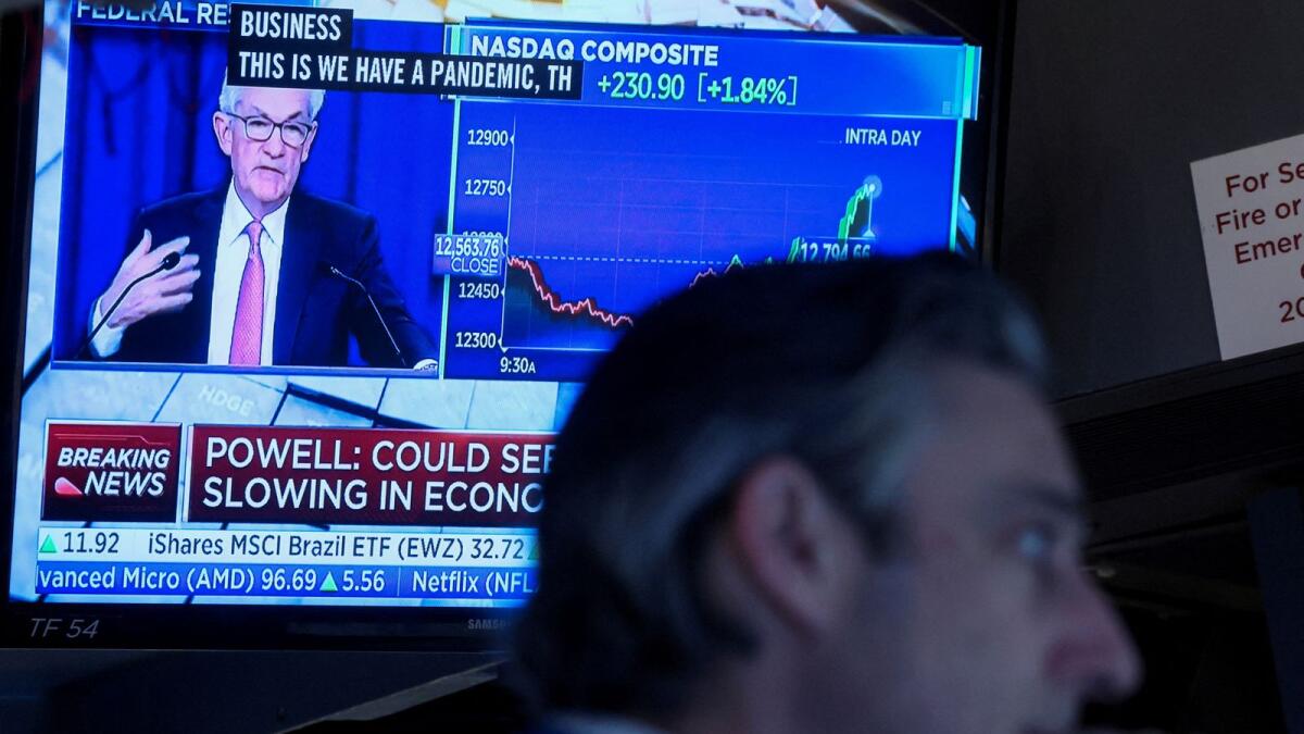 FILE PHOTO: A trader works, as Federal Reserve Chair Jerome Powell is seen delivering remarks on a screen, on the floor of the New York Stock Exchange (NYSE) in New York City, U.S. May 4, 2022. REUTERS/Brendan McDermid/File Photo