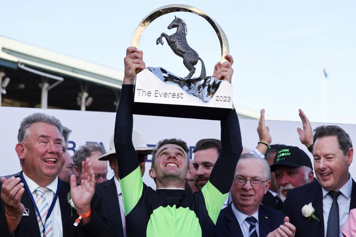Jockey Sam Clipperton , rider of Australian sprinter Think About It, lifts the Everest trophy after winning the world's richest turf race in Sydney on Saturday. - AFP