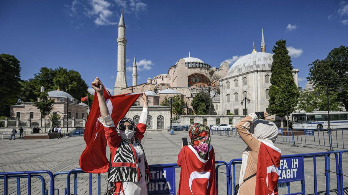 Woman with Turkish national flags gather outside the Hagia Sophia museum in Istanbul to celebrate after a top Turkish court revoked the sixth-century Hagia Sophia's status as a museum, clearing the way for it to be turned back into a mosque. Photo: AFP