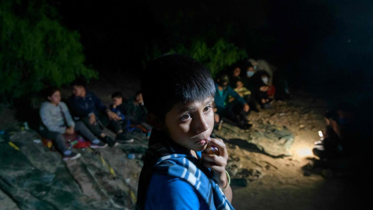 In a photo taken on March 27, 2021 unaccompanied Guatemalan child immigrant Oscar (12), who arrived illegally across the Rio Grande river from Mexico, stands after disembarking from a boat near the US border city of Roma.