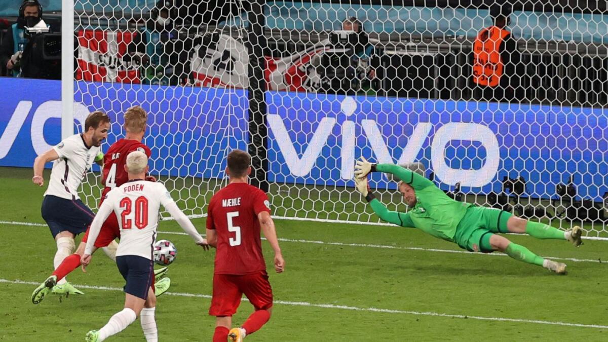 England's forward Harry Kane (left) shoots to score the second goal past Denmark's goalkeeper Kasper Schmeichel during the Euro 2020 semifinal. — AFP