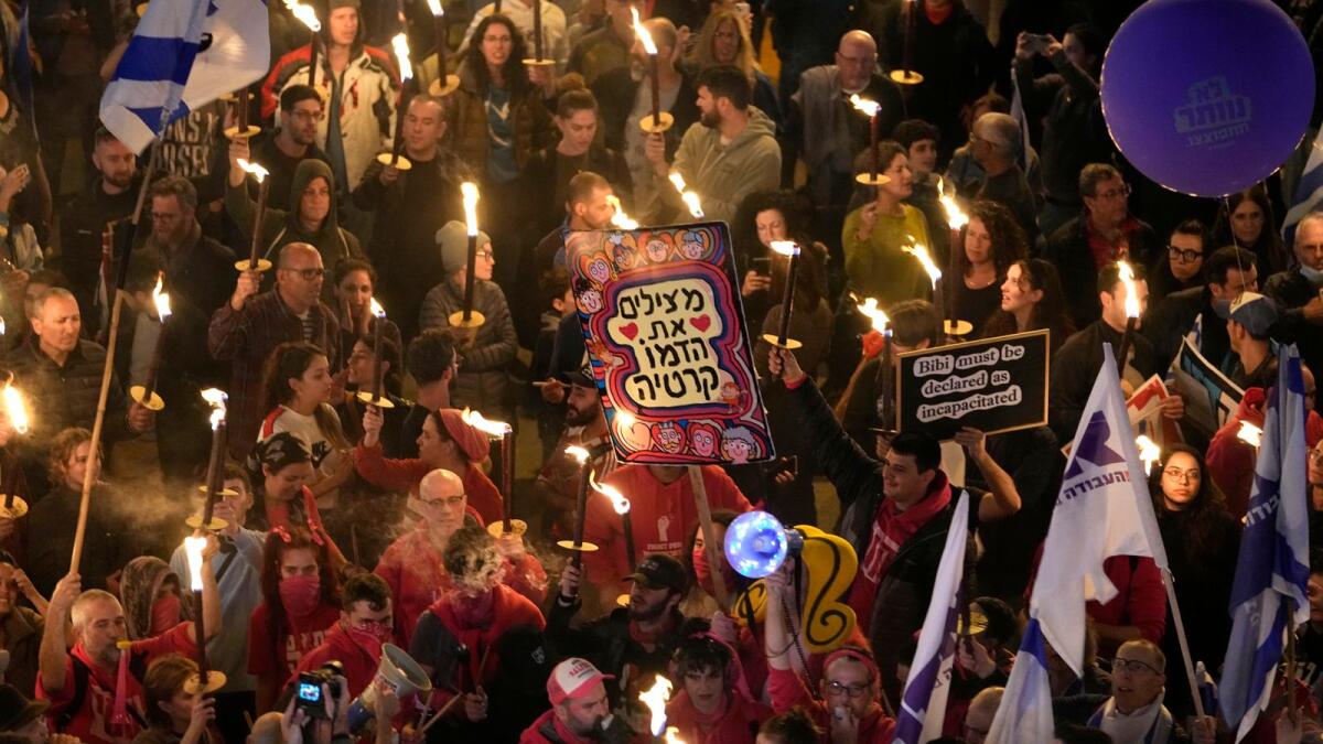 Israelis carry torches at a protest against Israeli Prime Minister Benjamin Netanyahu and his far-right government in Tel Aviv. — AP
