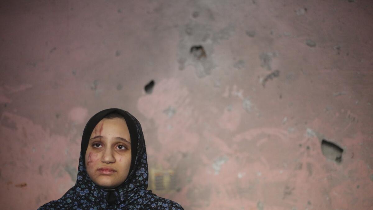 A Palestinian woman stands in her home after an Israeli strike in Rafah. — AP