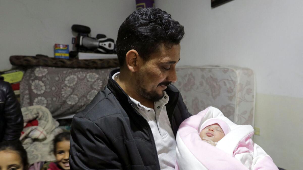 Khalil Al Sawadi, the uncle-by-marriage of a baby girl born during a deadly earthquake earlier this month, holds her, in rebel-held town of Jandaris, Syria, on Saturday. — Reuters