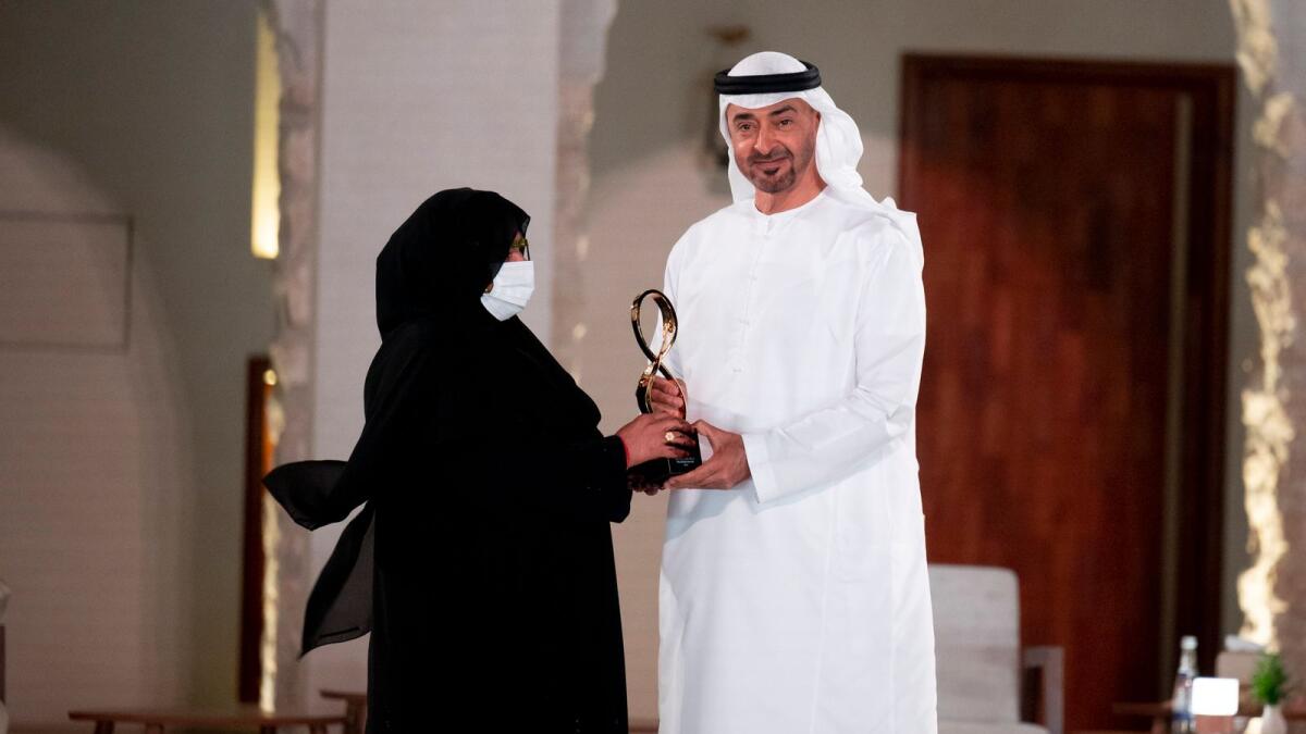 Sheikh Mohamed presents an award to Ghubaisha Al Ketbi.