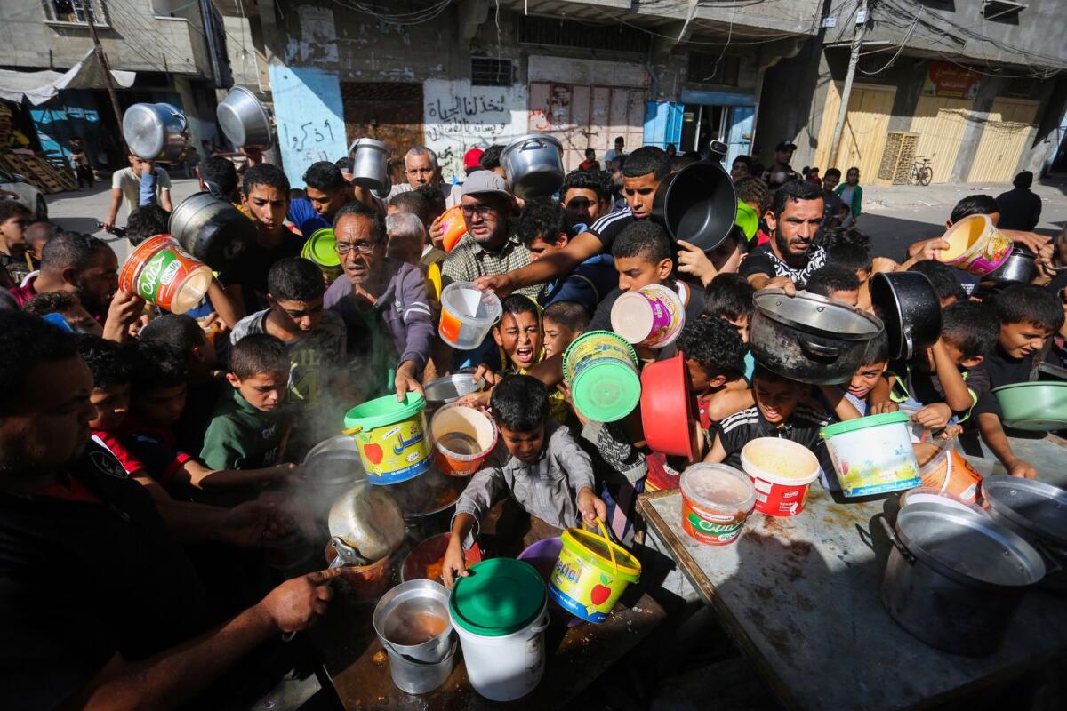 Palestinians crowded together as they wait for food distribution in Rafah, southern Gaza Strip, on Wednesday. — AP