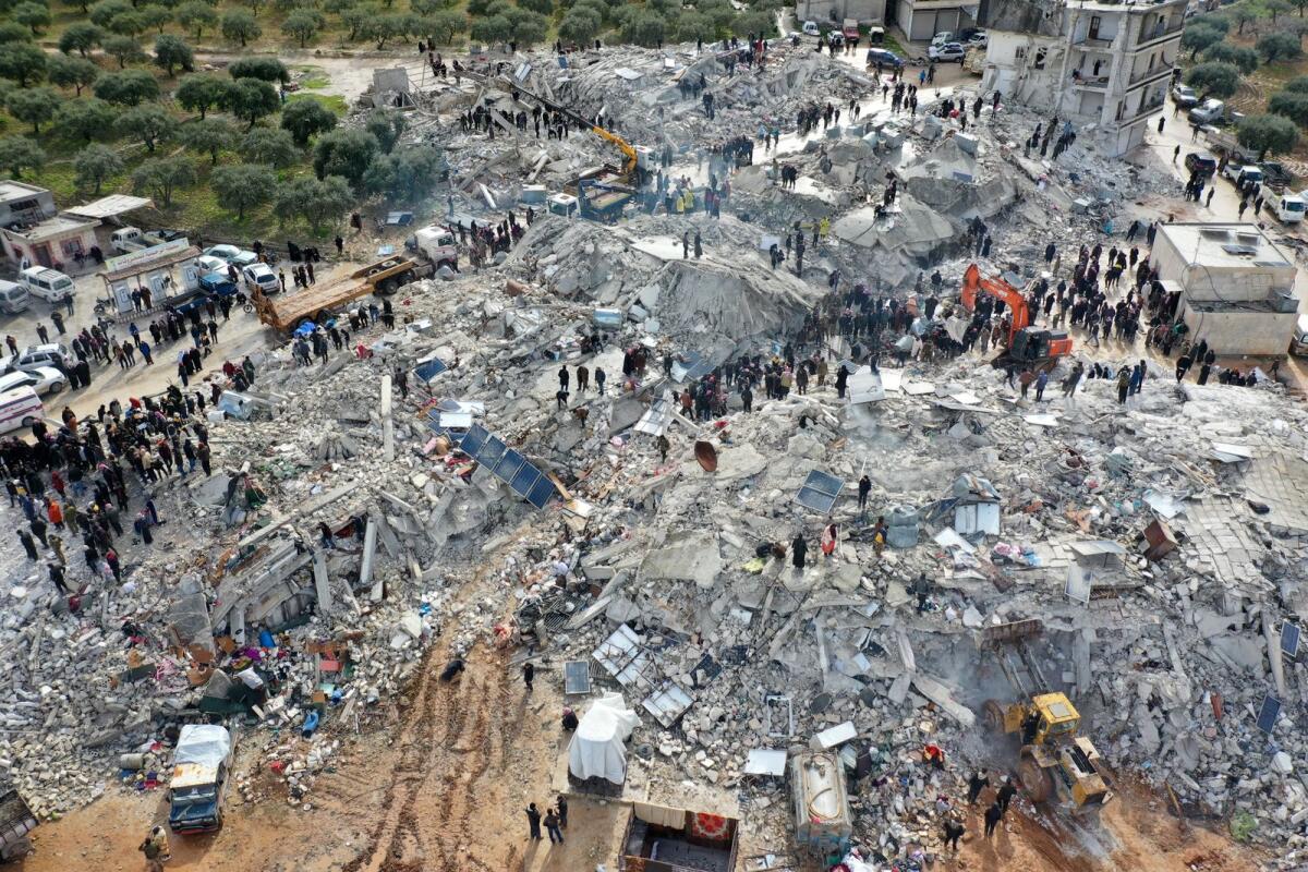 This aerial view shows residents searching for victims and survivors amidst the rubble of collapsed buildings. Photo: AFP