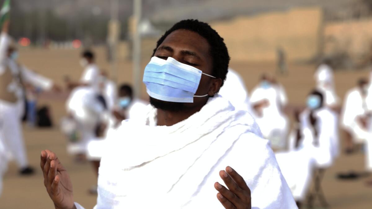 A pilgrim prays near the rocky hill known as Mountain of Mercy on the Plain of Arafat, as he wears a mask to protect himself against coronavirus during the annual Haj pilgrimage near the holy city of Makkah, Saudi Arabia. Photo: AP