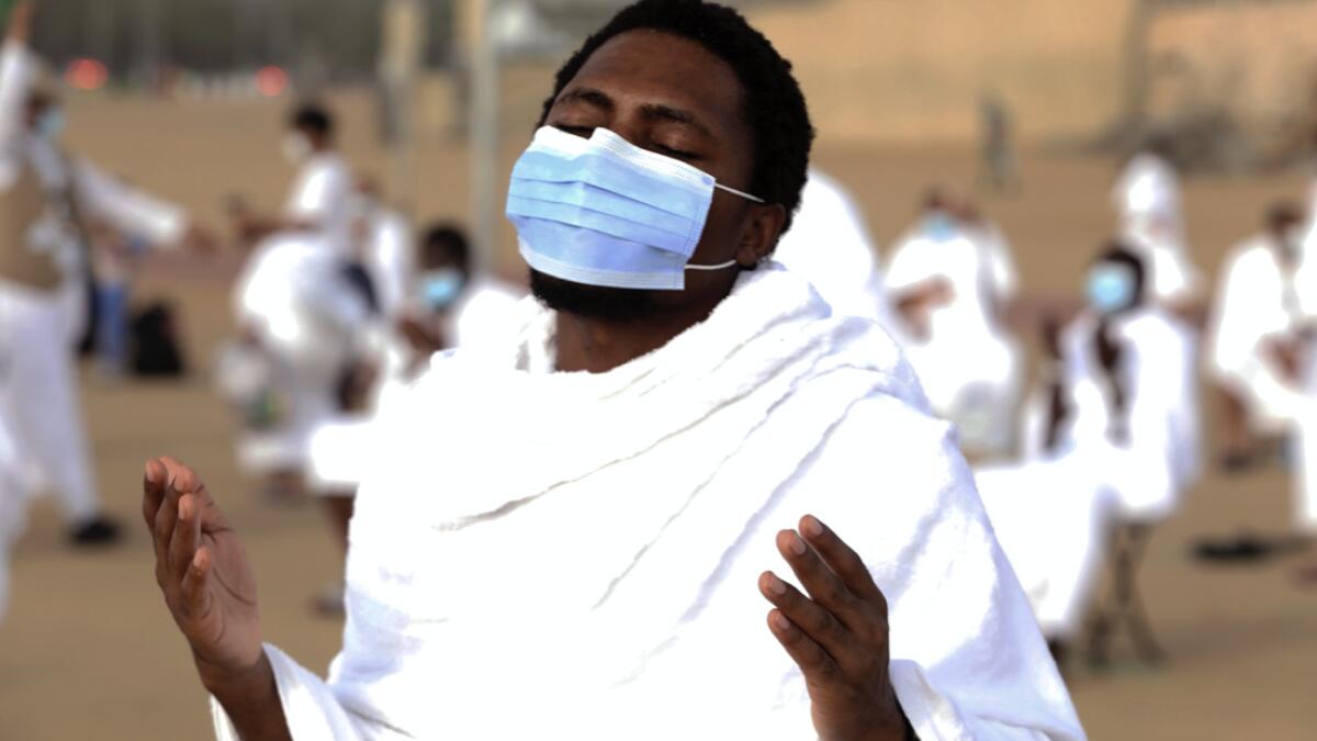 A pilgrim prays near the rocky hill known as Mountain of Mercy on the Plain of Arafat, as he wears a mask to protect himself against coronavirus during the annual Haj pilgrimage near the holy city of Makkah, Saudi Arabia. Photo: AP