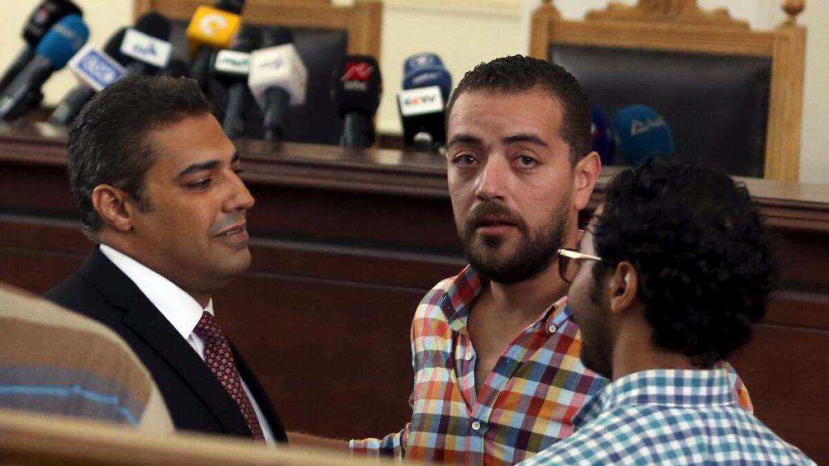 Al Jazeera television journalists Mohamed Fahmy (L) and Baher Mohamed (2nd L) talk inside a court in Cairo, Egypt. 