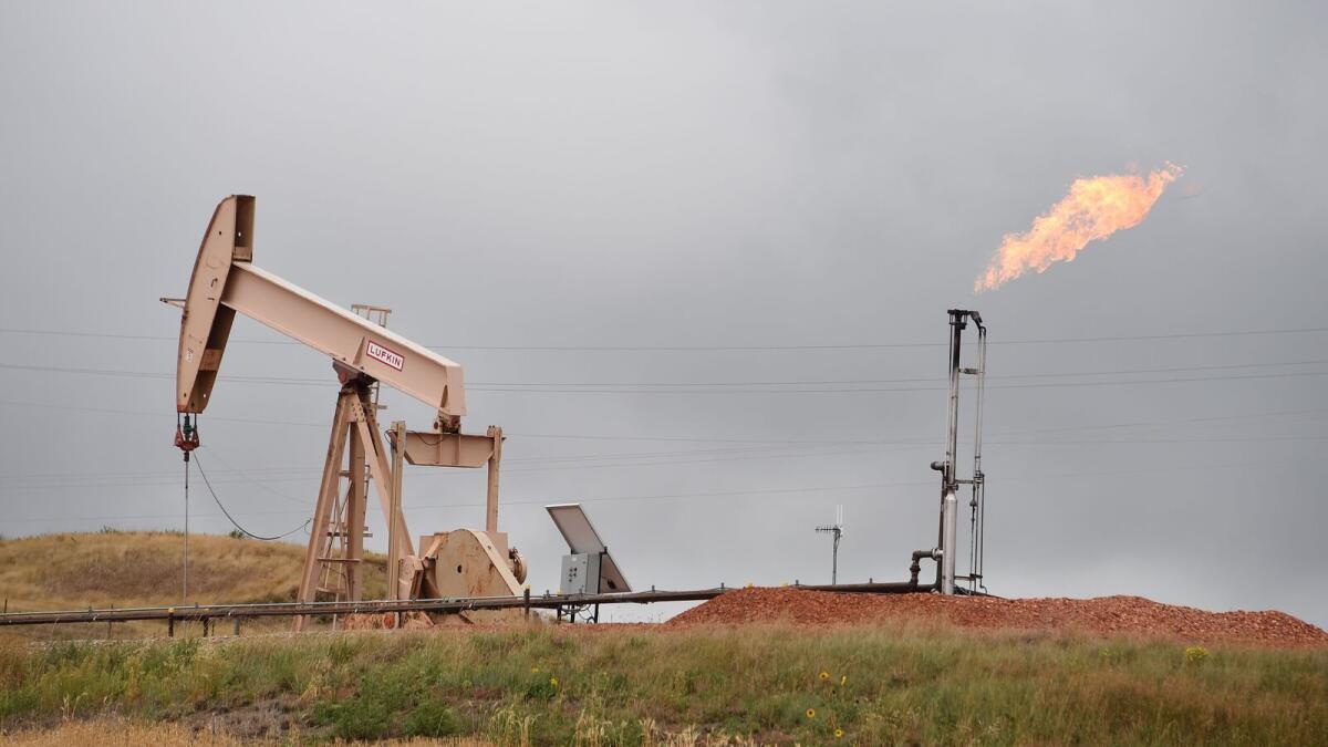 Pump jacks and a gas flare are seen near Williston, North Dakota. Crude prices have fallen significantly from their peak levels earlier in the year. - AFP file