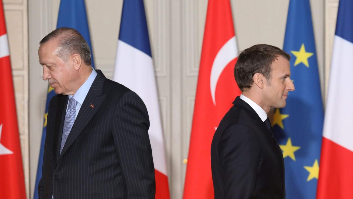 In this file photo taken on January 5, 2018 French President Emmanuel Macron (R) and  Turkish President Recep Tayyip Erdogan walk during a joint press conference at the Elysee Palace in Paris.