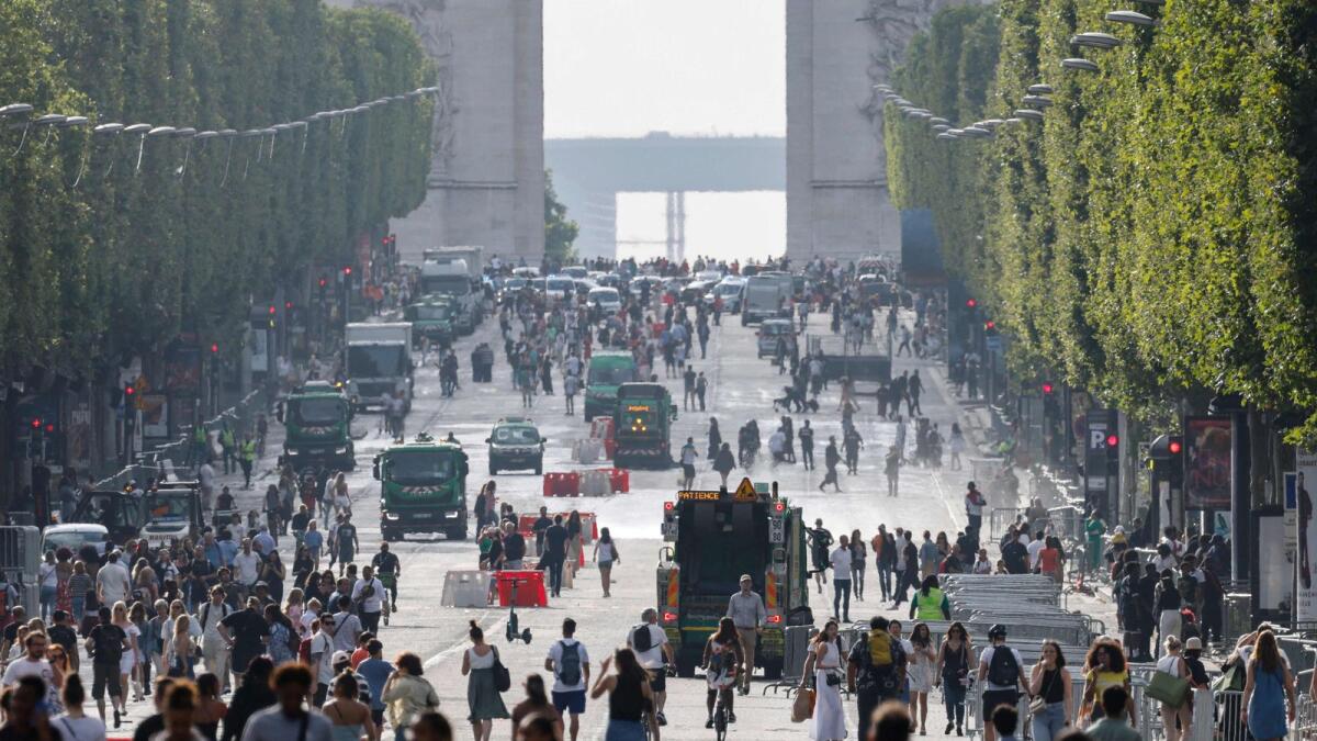 Pedestrians walk on Champs-Elysees avenue in Paris, on July 2, 2023, a day after protesters took to the street and clashed with police on an iconic street popular with tourists during a protest against the police killing of a 17-year-old teenage boy.  — AFP