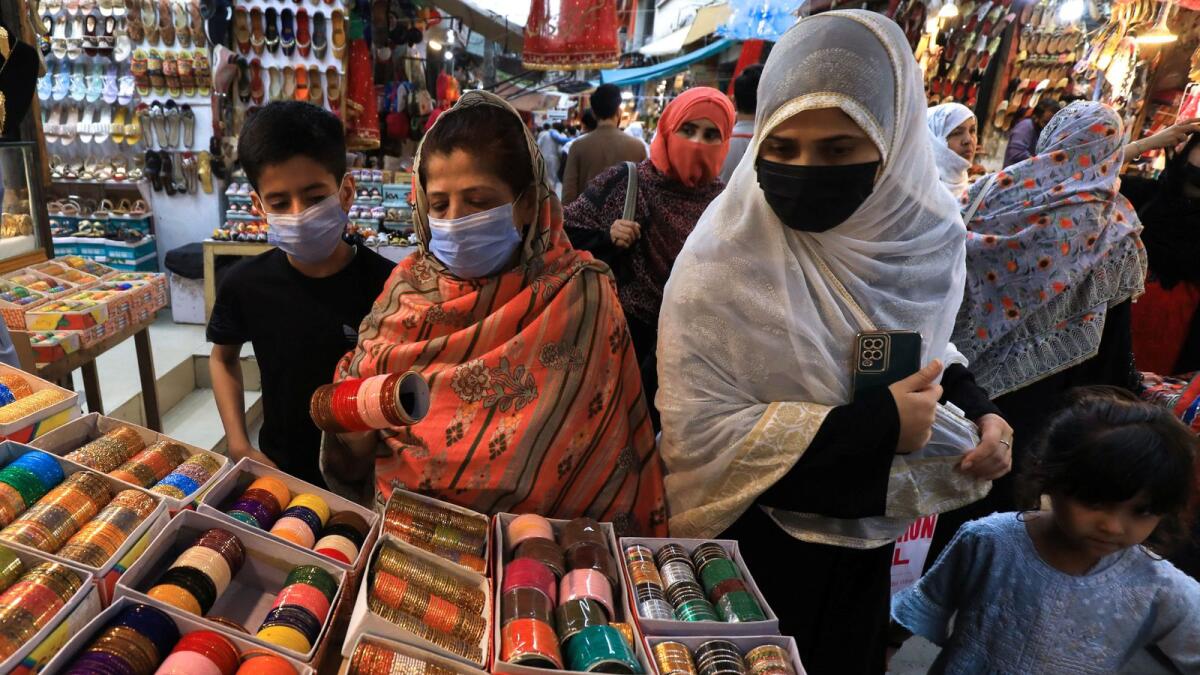 Women buy bangles from a stall, ahead of Eid al-Fitr celebrations, in Peshawar, Pakistan April 20, 2023. REUTERS/Fayaz Aziz