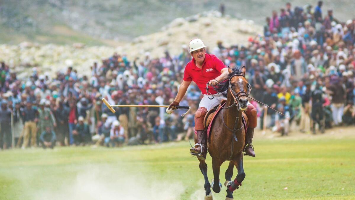 A horse running towards the centre of the ground in a polo match.