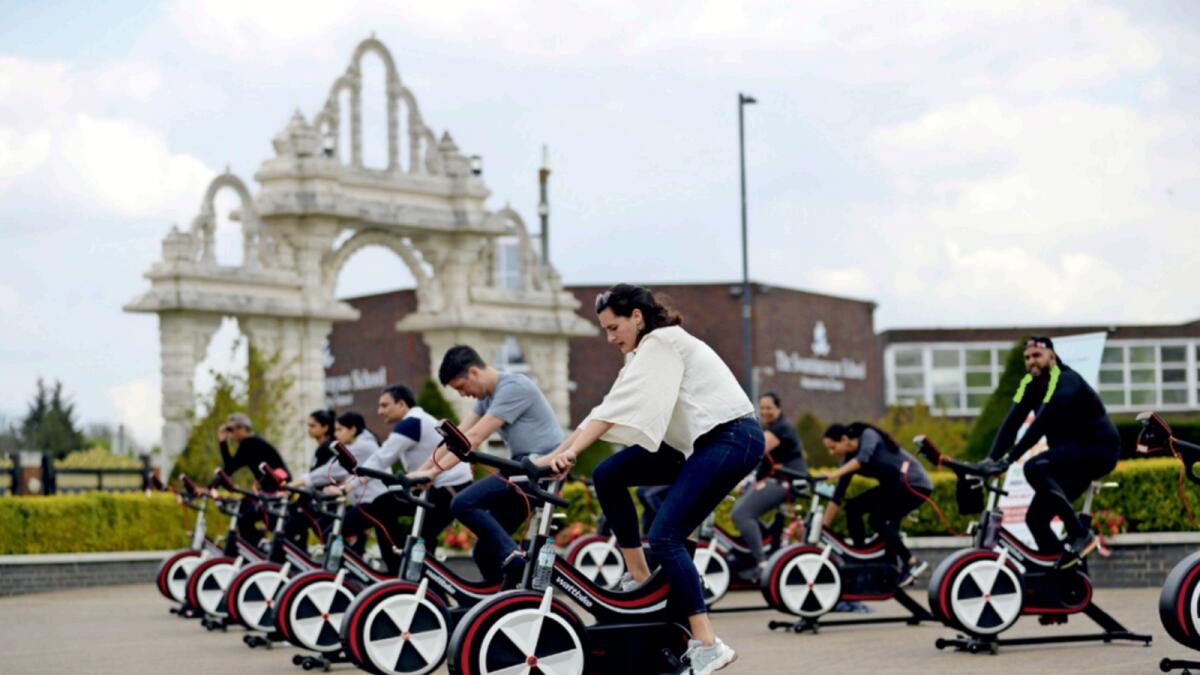 People take part in Cycle to Save Live, a 48 hour, non-stop static relay cycle challenge at the BAPS Shri Swaminarayan Mandir in north London to raise money to help coronavirus relief efforts in India. — AP