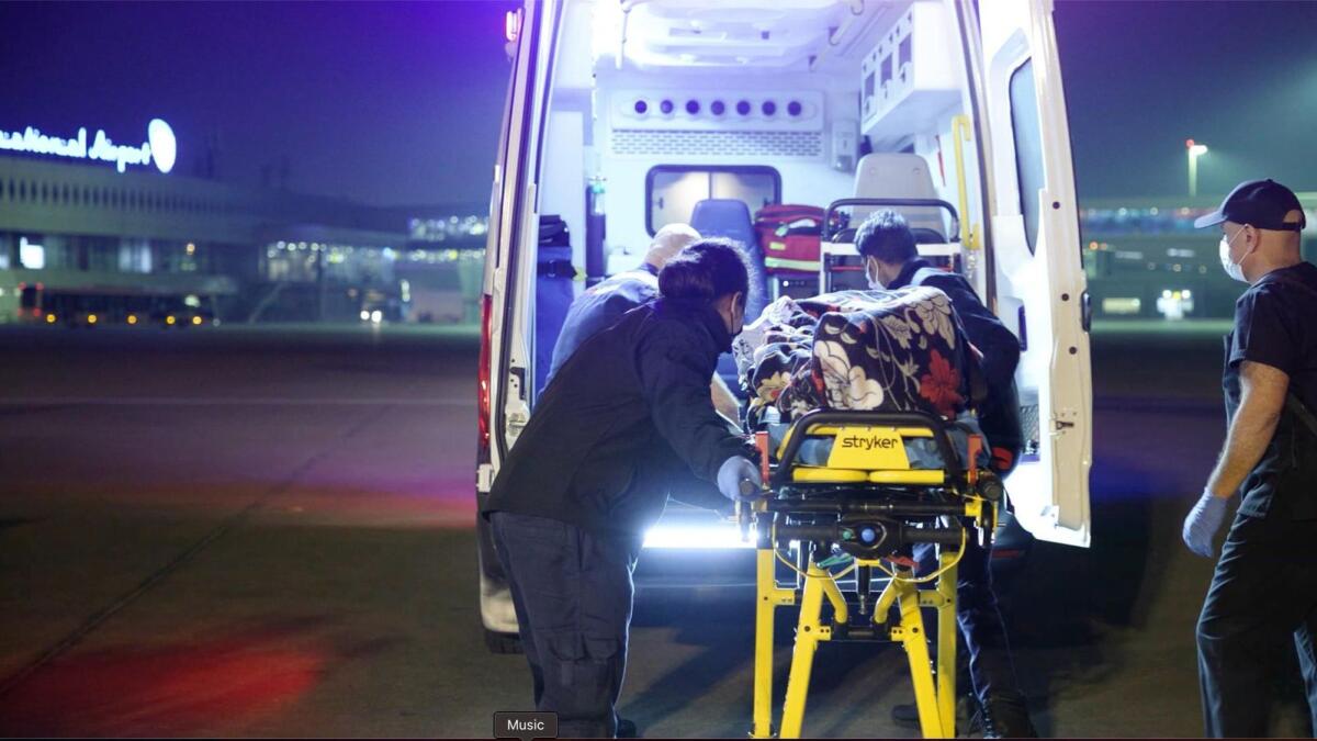 A Palestinian patient is being transported to ambulance at Abu Dhabi airport. - Wam