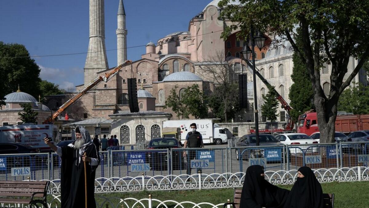 People sit outside Hagia Sophia as they wait for the beginning of Friday prayers, for the first time after it was once again declared a mosque after 86 years. Reuters