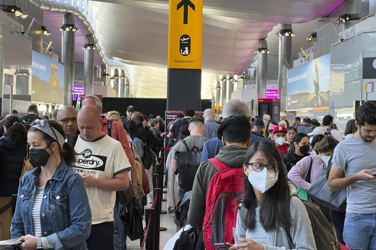 FILE - Travellers queue at security at Heathrow Airport in London. Photo: AFP