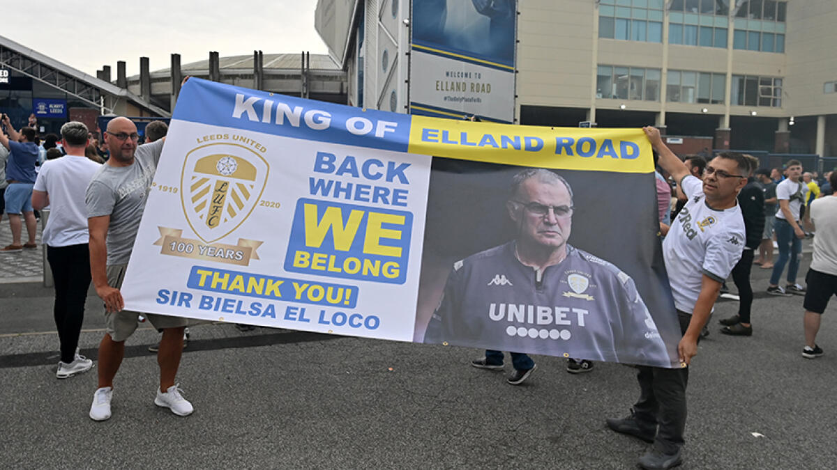 Leeds United supporters hold up a large banner as they gather outside their Elland Road ground to celebrate the club's return to the Premier League after a gap of 16 years. -- AFP
