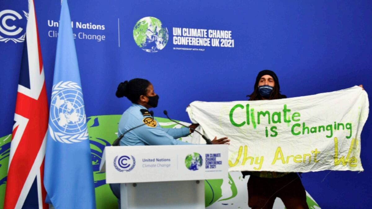 A protester holds a banner during the UN Climate Change Conference (COP26) in Glasgow. — Reuters