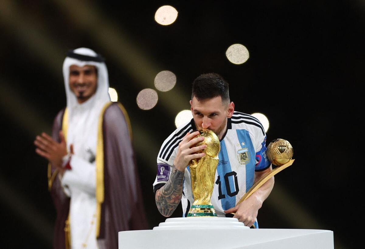 Messi kisses the World Cup trophy after collecting the Golden Ball award. — Reuters