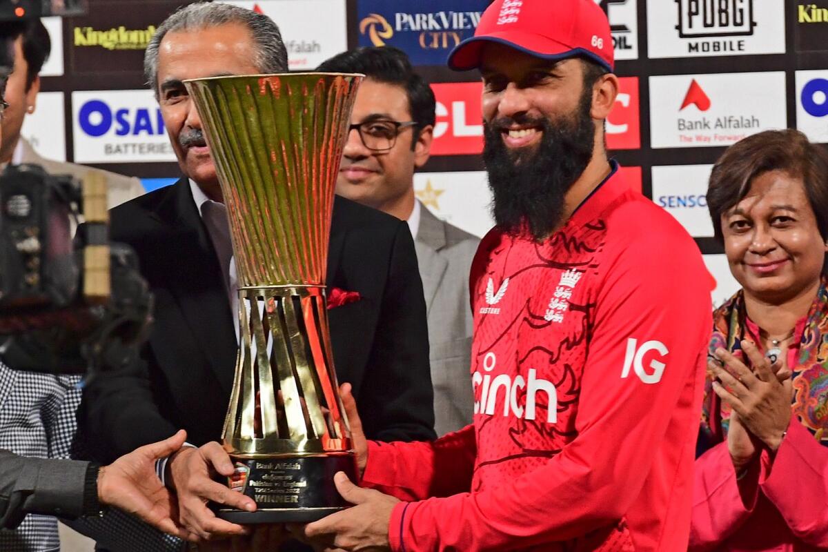 England's stand-in captain Moeen Ali holds the trophy after winning the T20 series against Pakistan at the Gaddafi Stadium in Lahore on Sunday. (AFP)