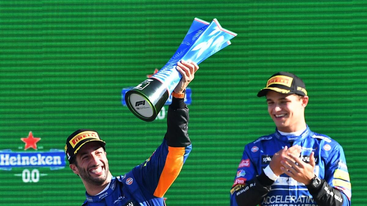 McLaren's Daniel Ricciardo celebrates with the trophy on the podium with after winning the Italian GP alongside second place McLaren's Lando Norris. — Reuters