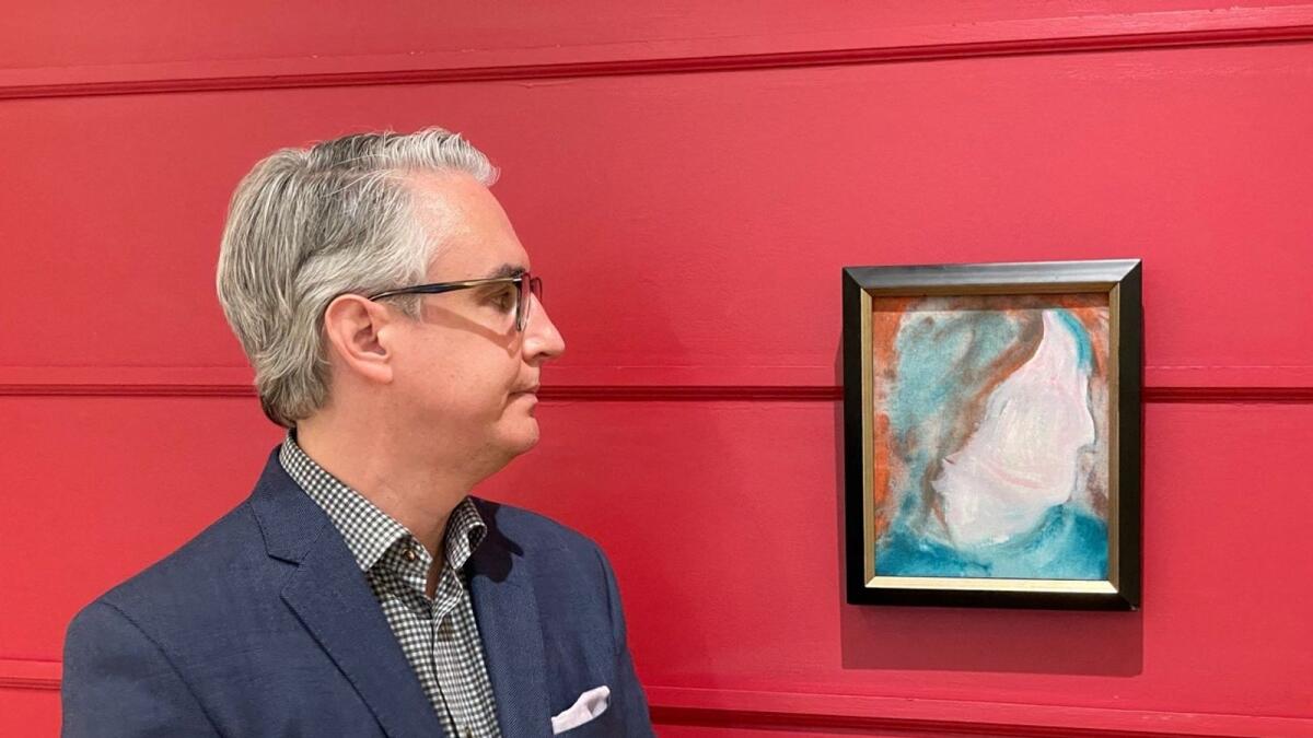 A Canadian Art Specialist Rob Cowley looks at a painting by British pop icon David Bowie in Toronto, Canada. Photo: AFP