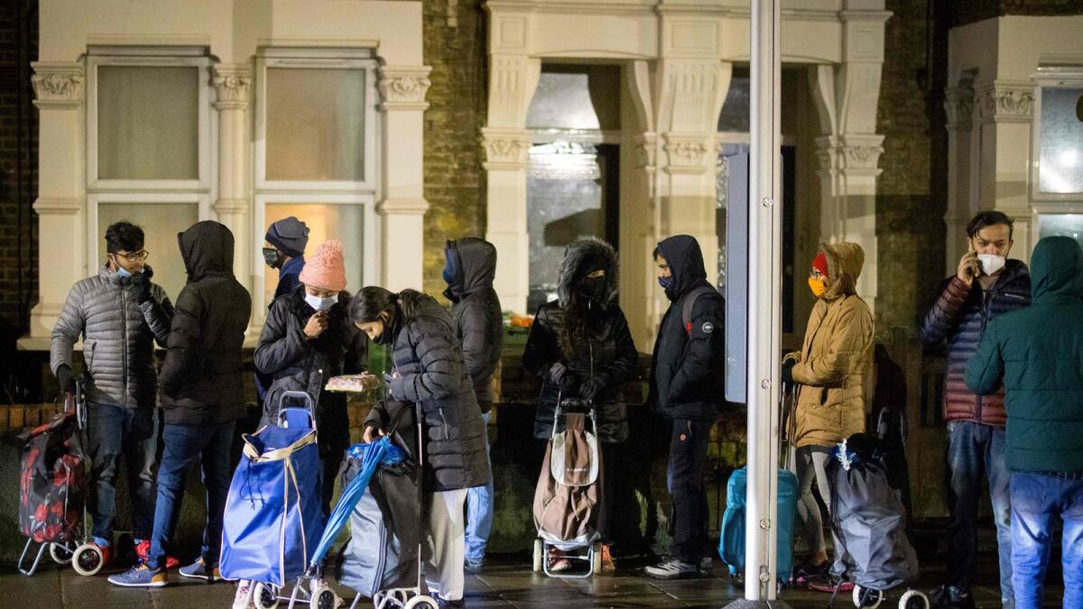 International students queue to collect food packages at the Newham Community Project food bank in east London on February 16, 2021.