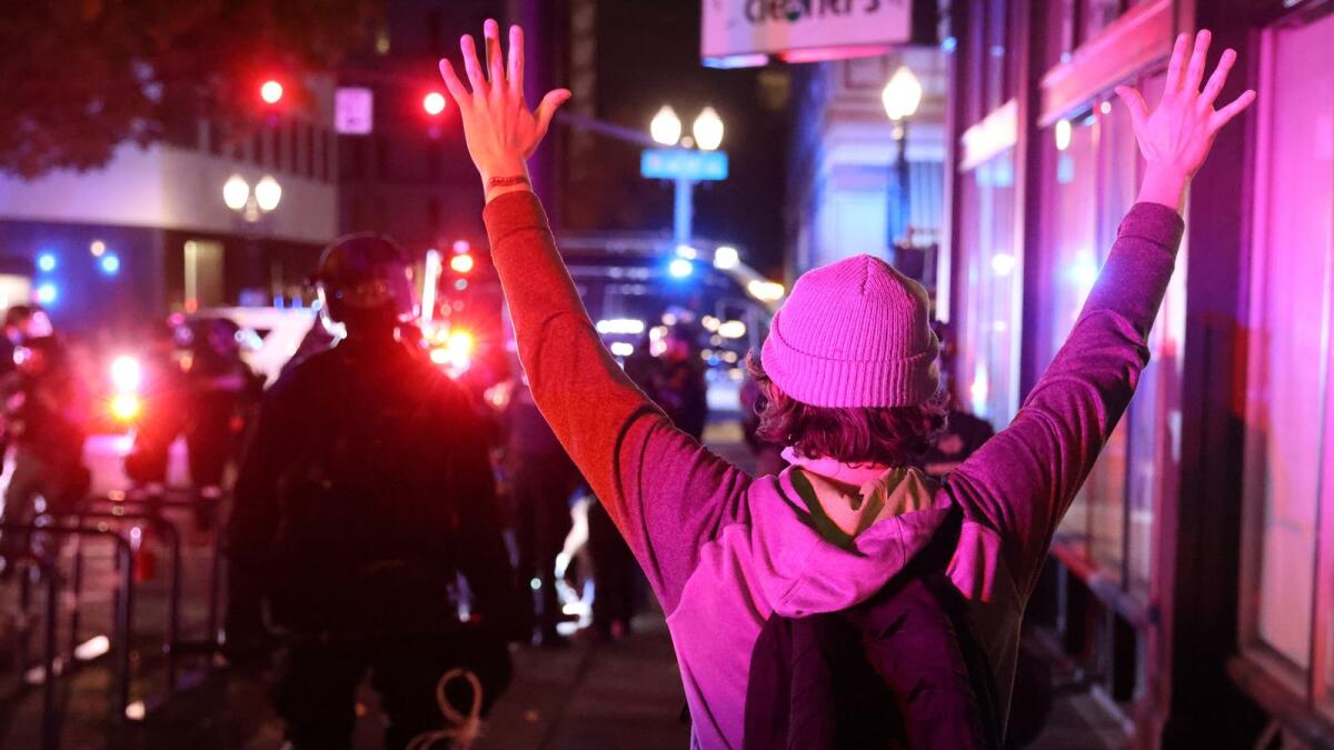 A demonstrator holds up hands in front of police during a protest. Reuters