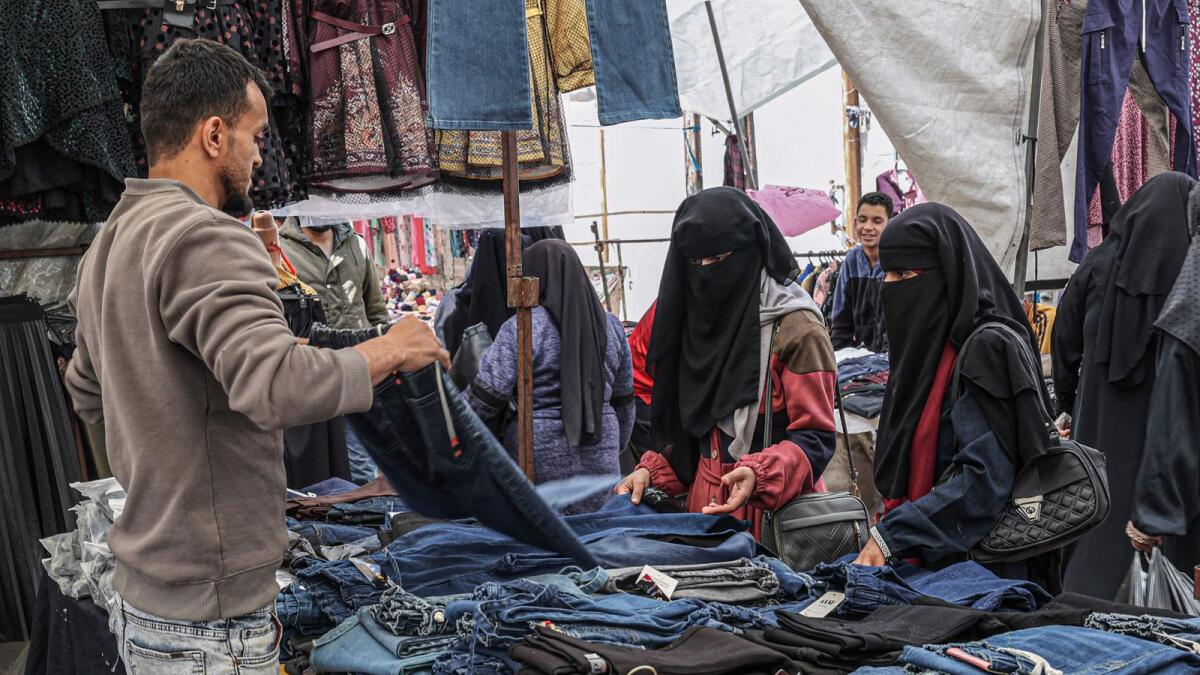 A Palestinian vendor displaying clothing at a market in Gaza City. — AFP