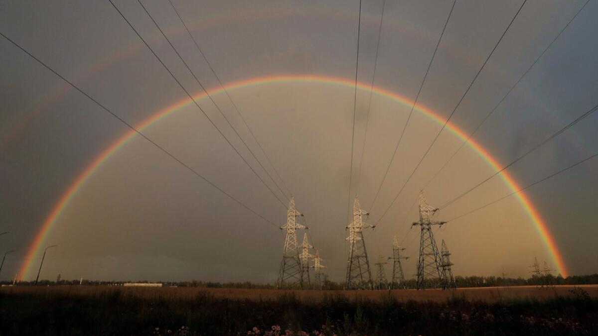 A rainbow is seen behind electrical pylons in a field near the town of Zhodino, Belarus. Photo: Reuters