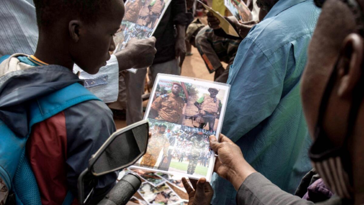 A young boy looks at a poster of new strong man and head of the Junta, Lieutenant-colonel Paul-Henri Sandaogo Damiba outside the Grand Mosque of Ouagadougou. — AFP